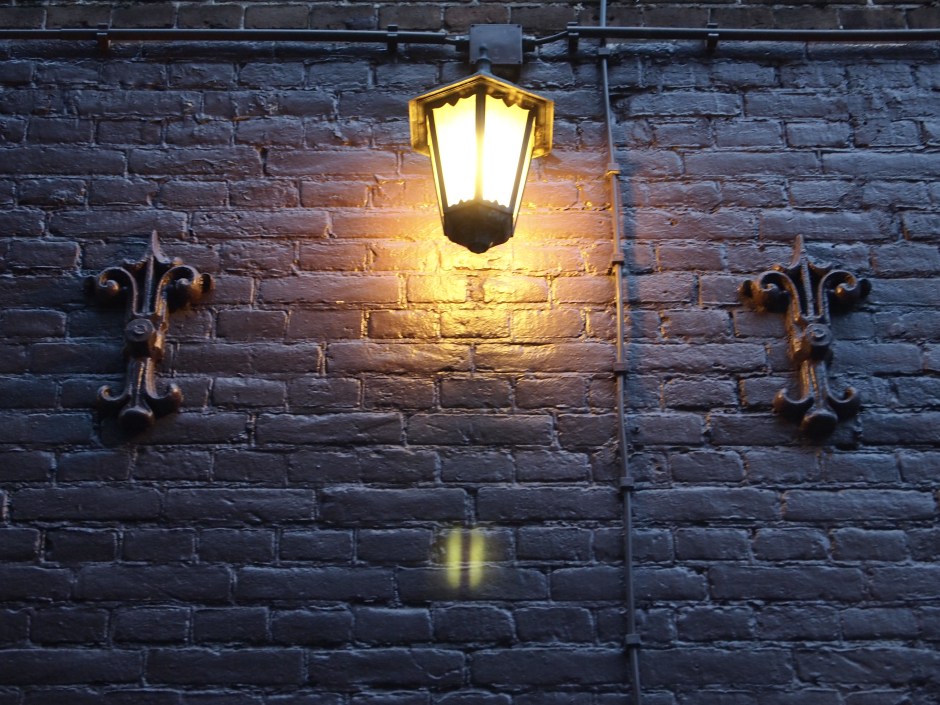 A lantern lights up a dark wall.